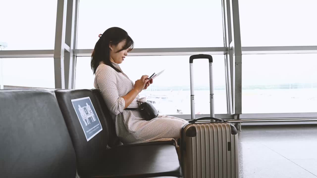 一位亚洲华裔女商人在机场等待她的航班。个人商务旅行理念。视频素材