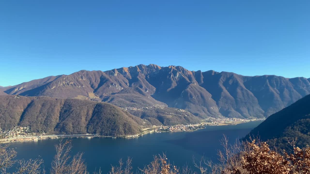 在阳光明媚的日子里，维科·莫科特卢加诺湖上的蒙特·杰诺索山景与村庄视频素材