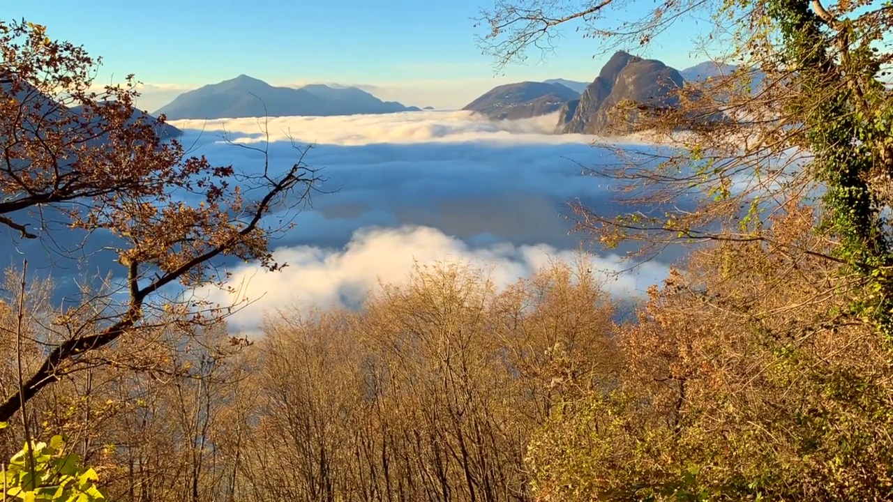 高山湖卢加诺的全景与云海和山在一个晴朗的秋日视频素材