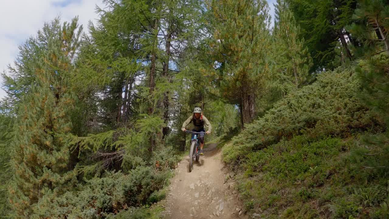 骑山地自行车的人在森林里的一条小路上骑行。骑手的观点，山地自行车在高山地形视频素材