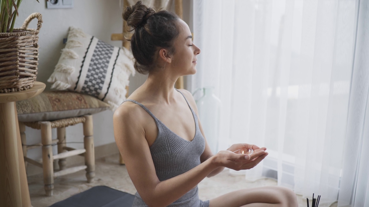 一个年轻女人在舒适的波西米亚房间里做瑜伽。视频素材