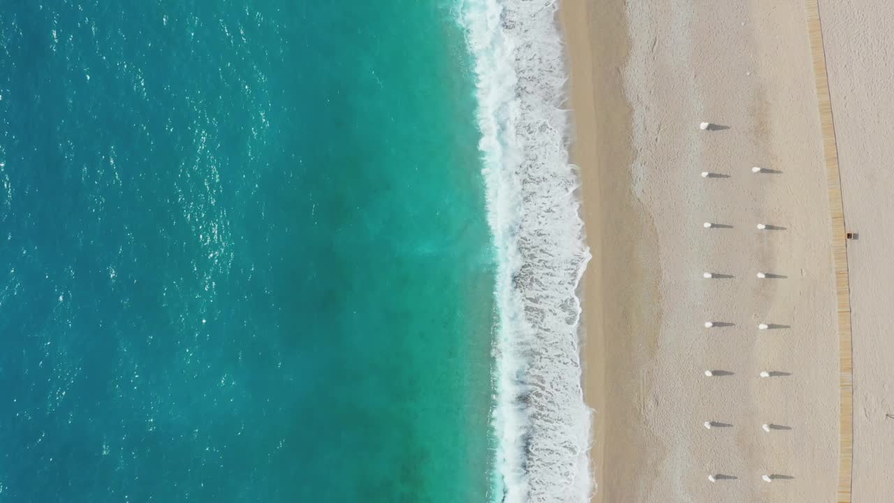 在土耳其的Oludeniz，带着遮阳伞的梦幻般的绿松石海滩鸟瞰视频素材