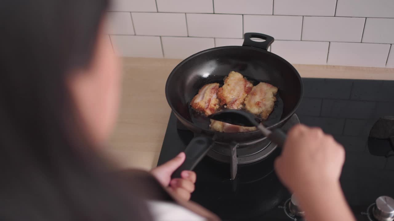 做亚洲菜的女人用鱼鳍煎猪肉视频素材