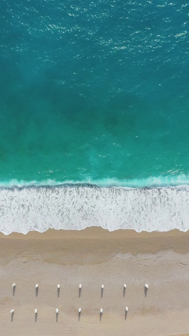 在土耳其的Oludeniz，带着遮阳伞的梦幻般的绿松石海滩鸟瞰视频素材