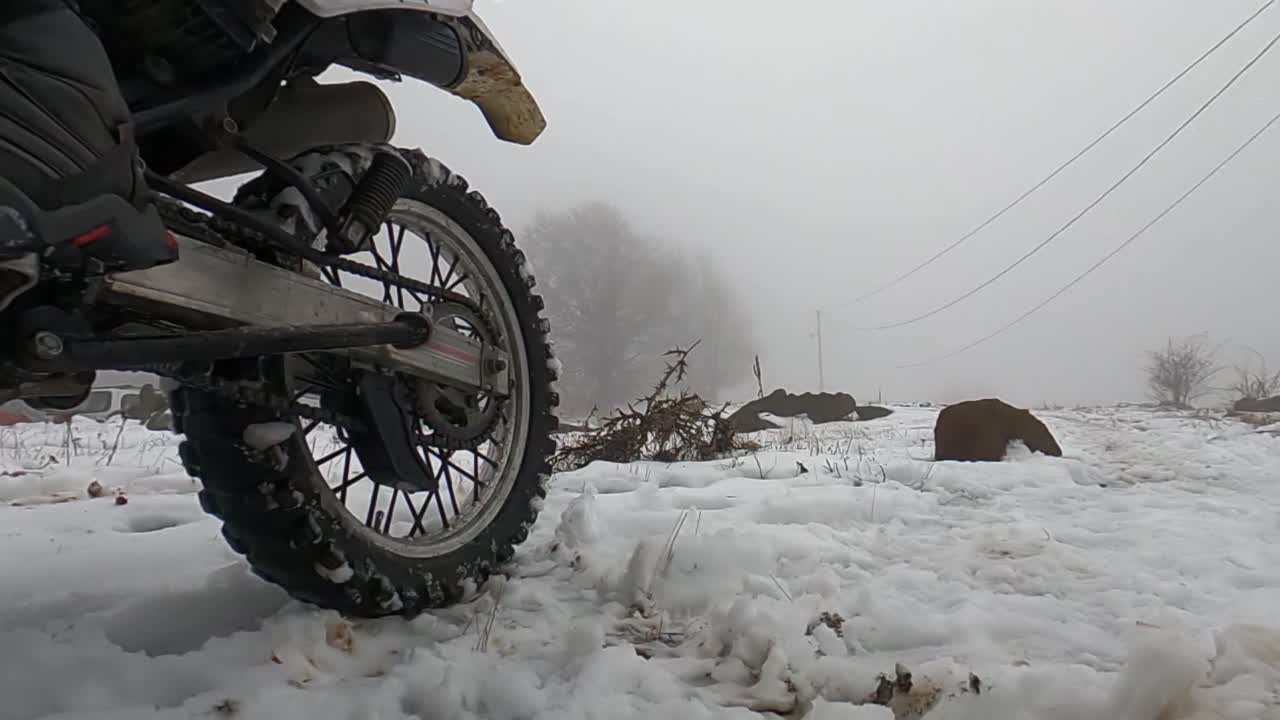 自定义摩托车轮胎的特写-漂移和轮胎烧毁在雪地上的技巧。慢动作视频素材