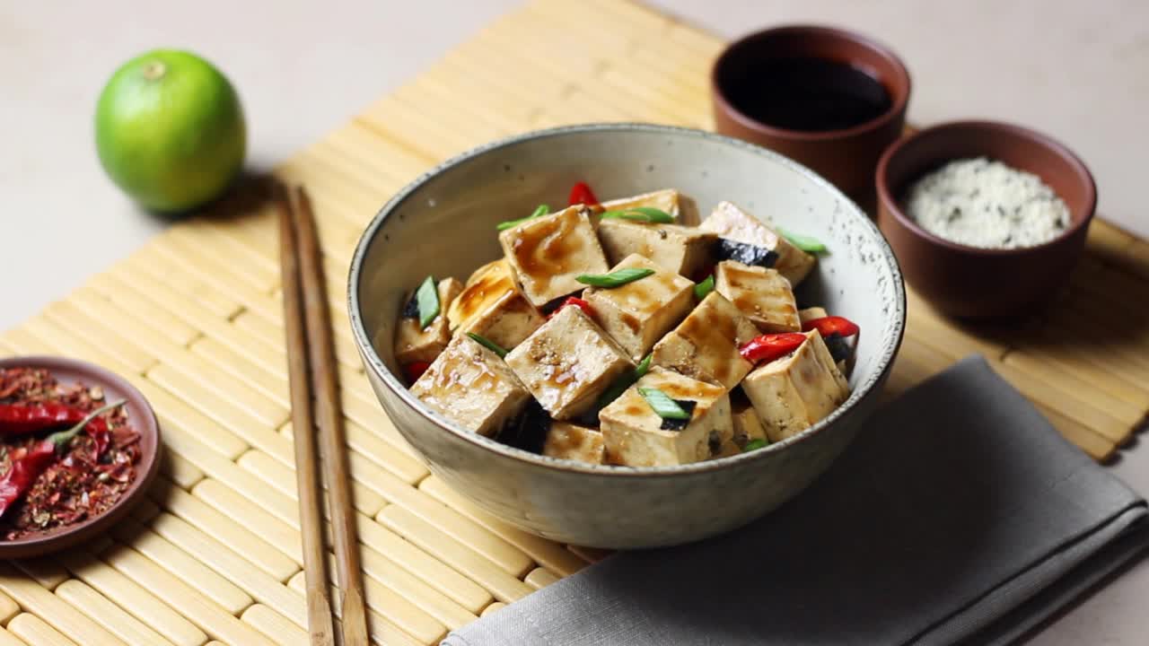 红烧豆腐配葱、辣椒和芝麻。亚洲食品。素食。健康饮食。视频素材