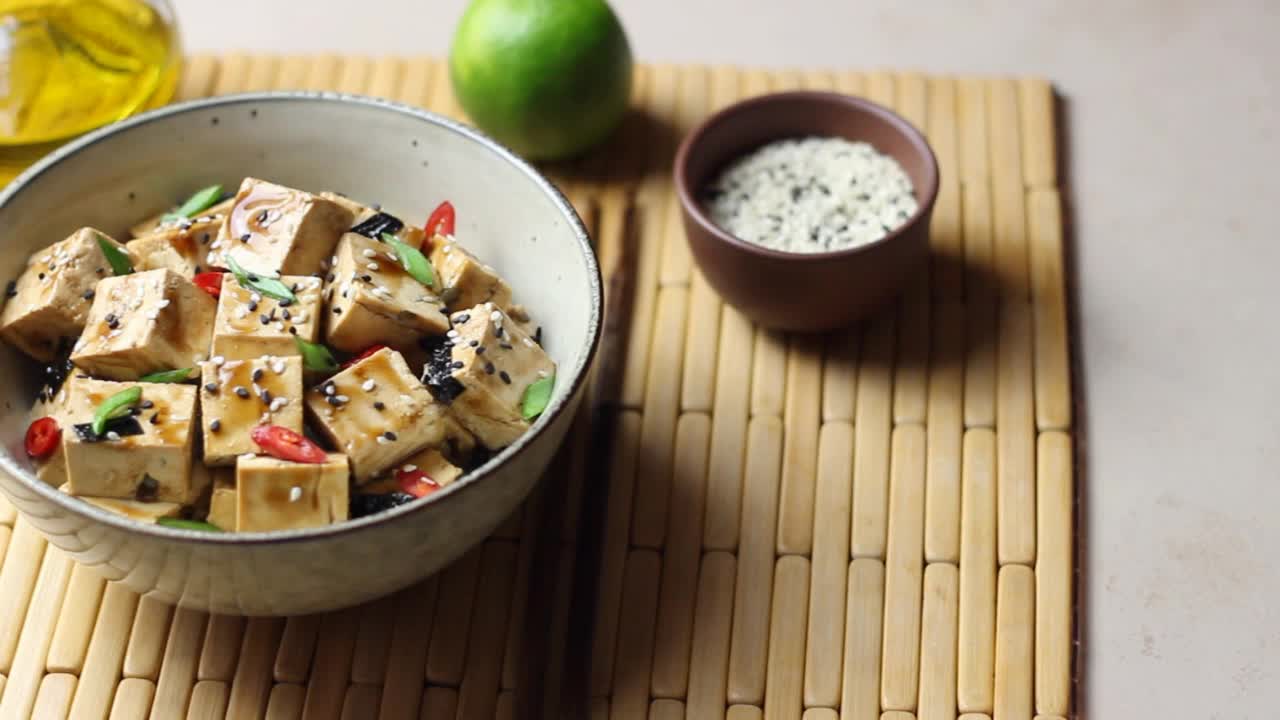 红烧豆腐配葱、辣椒和芝麻。亚洲食品。素食。健康饮食。视频素材