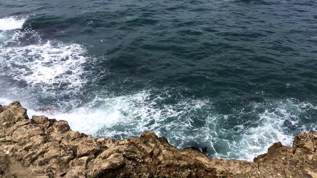 蓝色的海浪拍打着海岸。视频素材