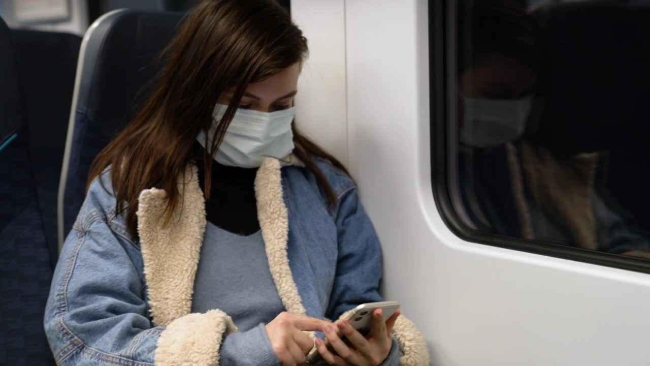 年轻女子在伦敦乘火车旅行时使用智能手机视频素材