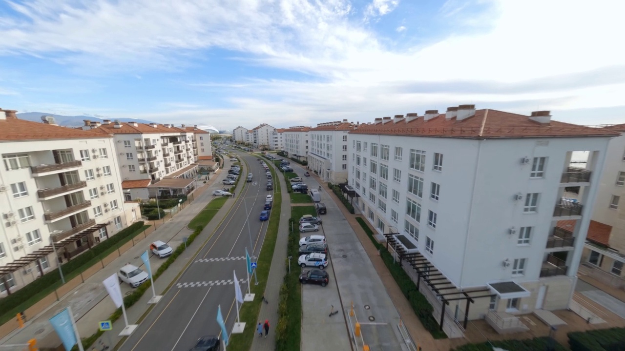 鸟瞰现代小型旅游城市街区建筑建筑沥青道路交通汽车山蓝天景观。无人机拍摄的酒店公寓镇外视频素材