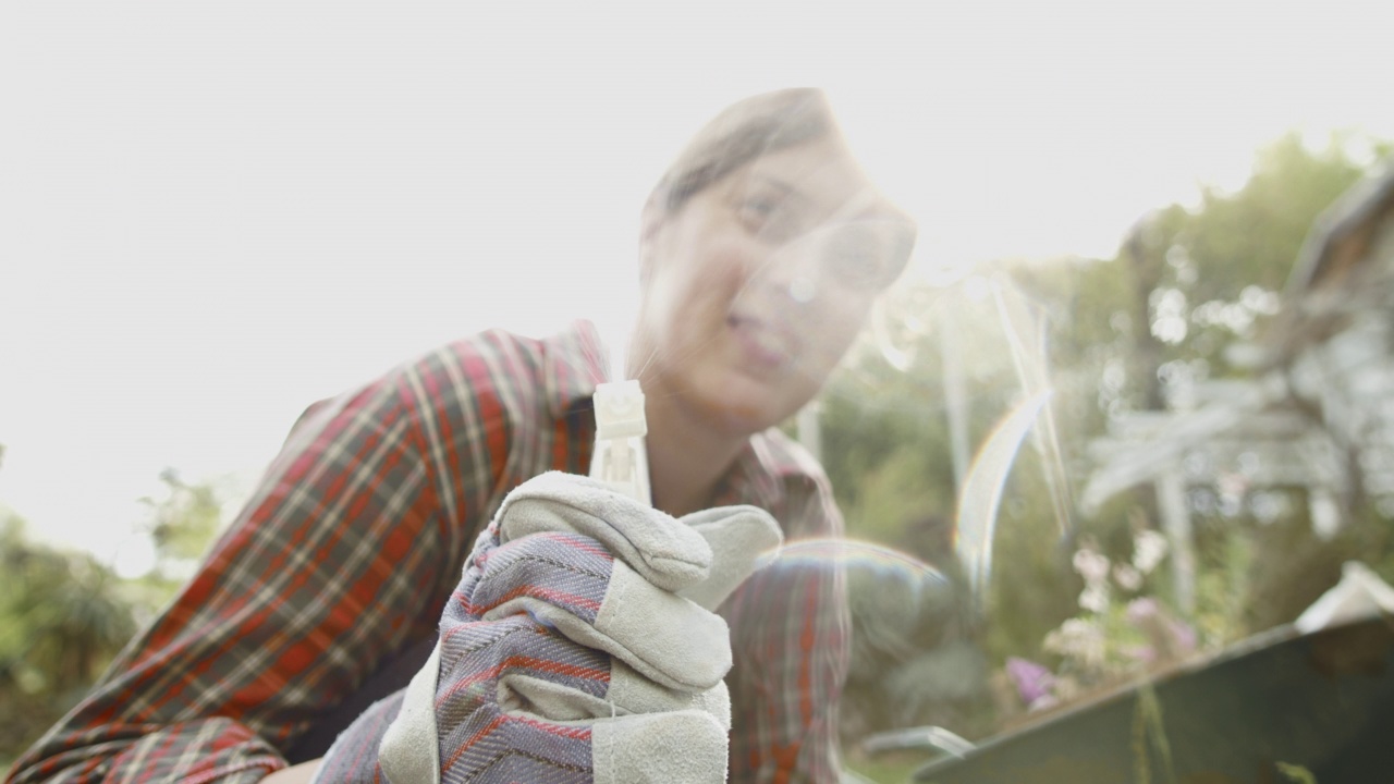 一个女人的特写与植物手套和一个水泵，而喷洒植物在她的花园。前面的大镜头。农业和植物学。国内的生活方式。股票视频。视频下载