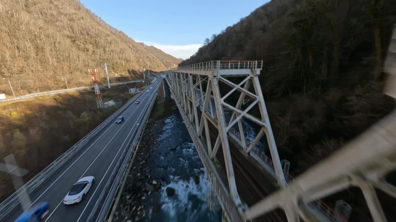 Fpv无人机查看公路交通白色运动汽车快速移动运输铁路桥梁山区河流。铁路上的空中拍摄旅游城市度假村车辆运动基础设施4k视频素材