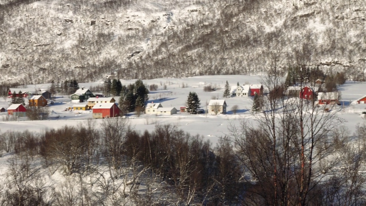 挪威冬季的全景，海边的房子和远处美丽的雪山视频素材