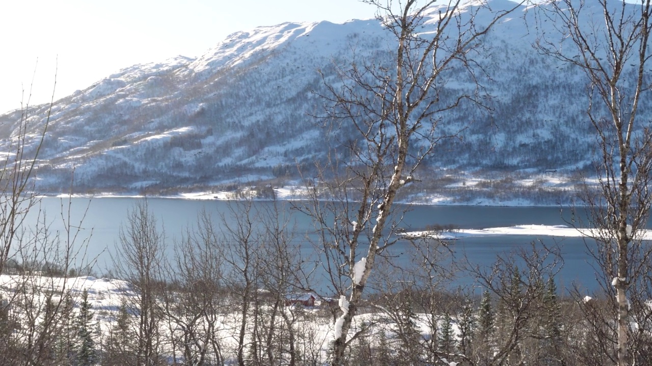 挪威冬季的全景，海边的房子和远处美丽的雪山视频素材