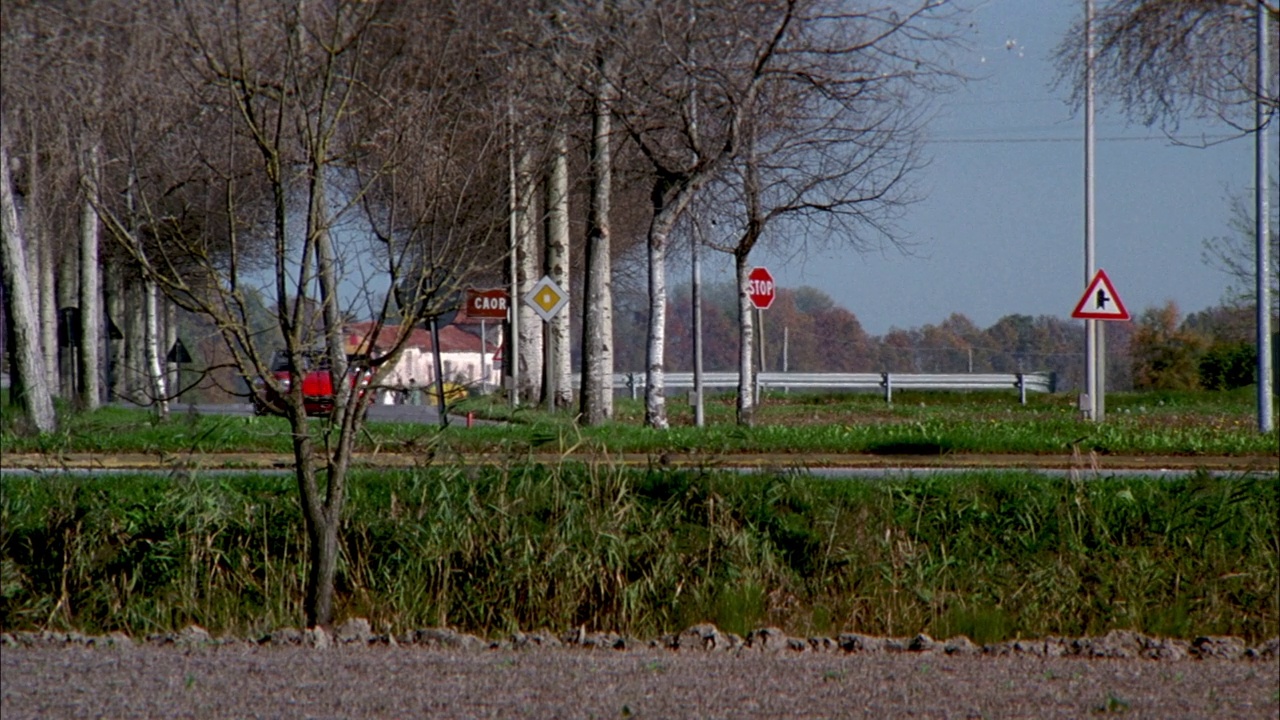 中角跟踪镜头红色保时捷接近pov在蜿蜒的乡村道路。黑色轿车从右边出现，红色保时捷从左边超过黑色轿车。在农村。跑车。视频素材