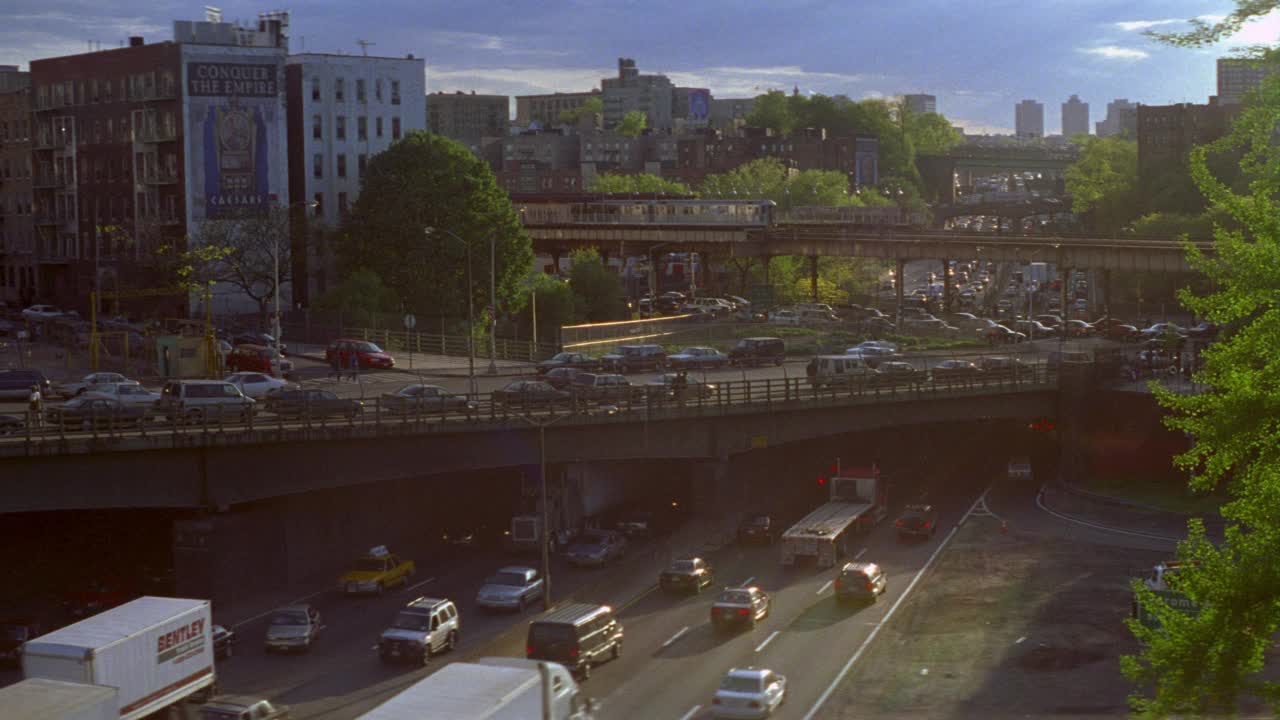 广角交通充满路口的道路，桥梁，高架列车，和隧道的入口。可能是布朗克斯，但也可以为布鲁克林或皇后区打球。视频素材