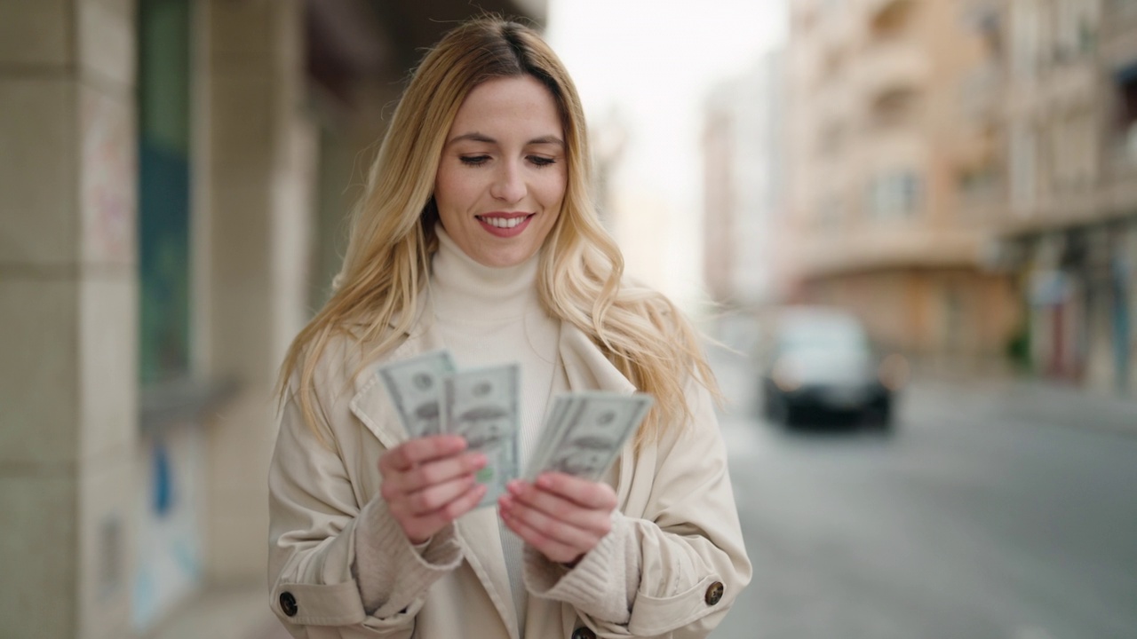 年轻的金发女子在街上自信地微笑着数美元视频素材