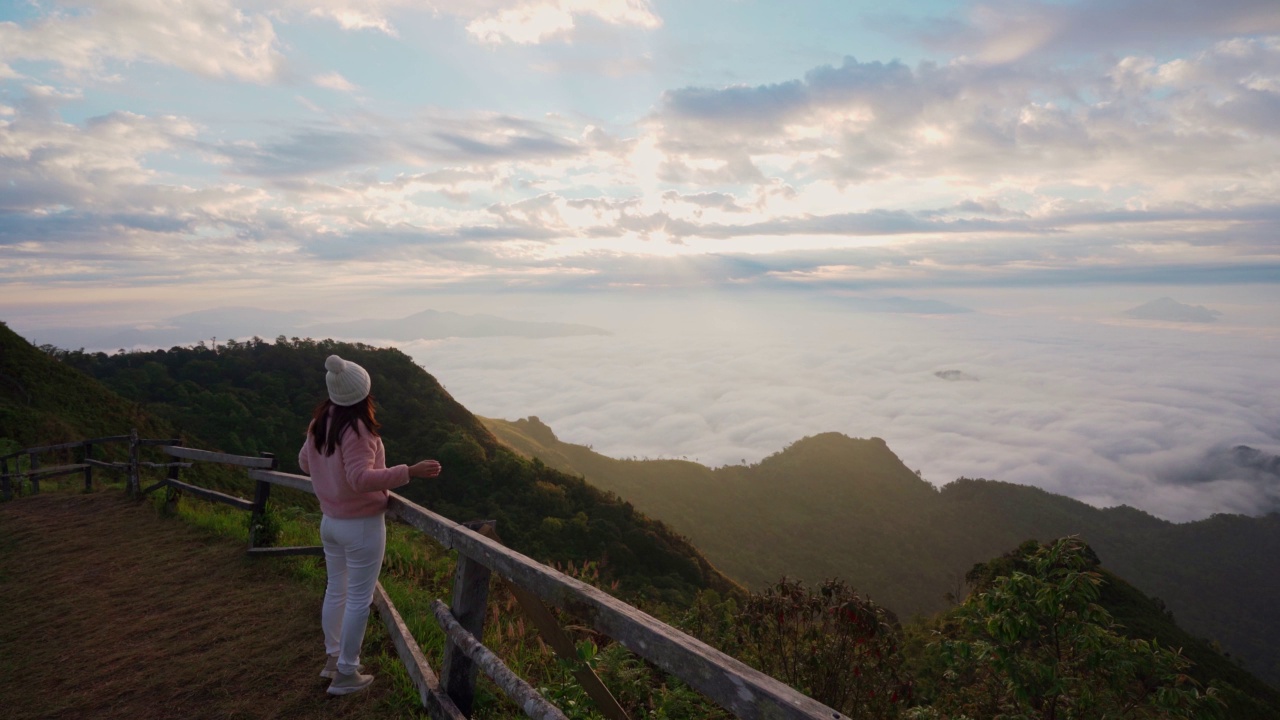 年轻的女游客早上在山上看日出和雾海，旅行的生活理念视频素材