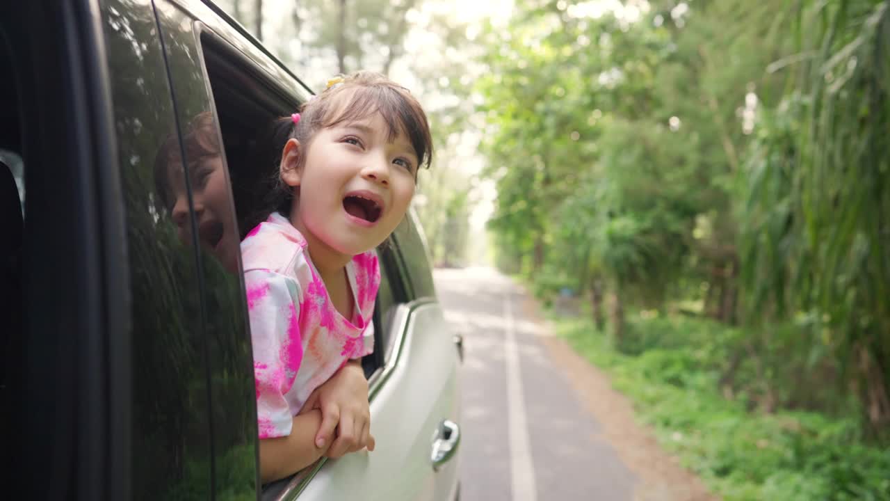 幸福的亚洲小女孩享受和家人在车在夏天的自驾游假期。视频素材