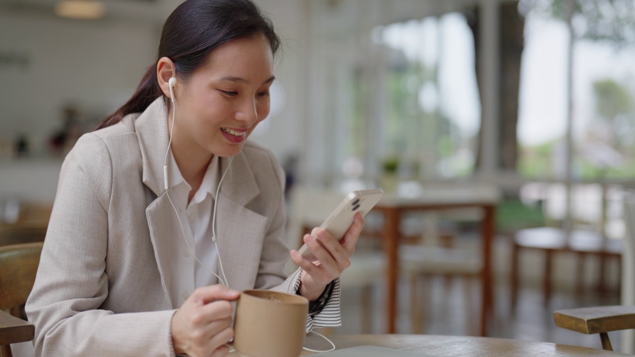 在咖啡店里看手机短信的女商人视频素材