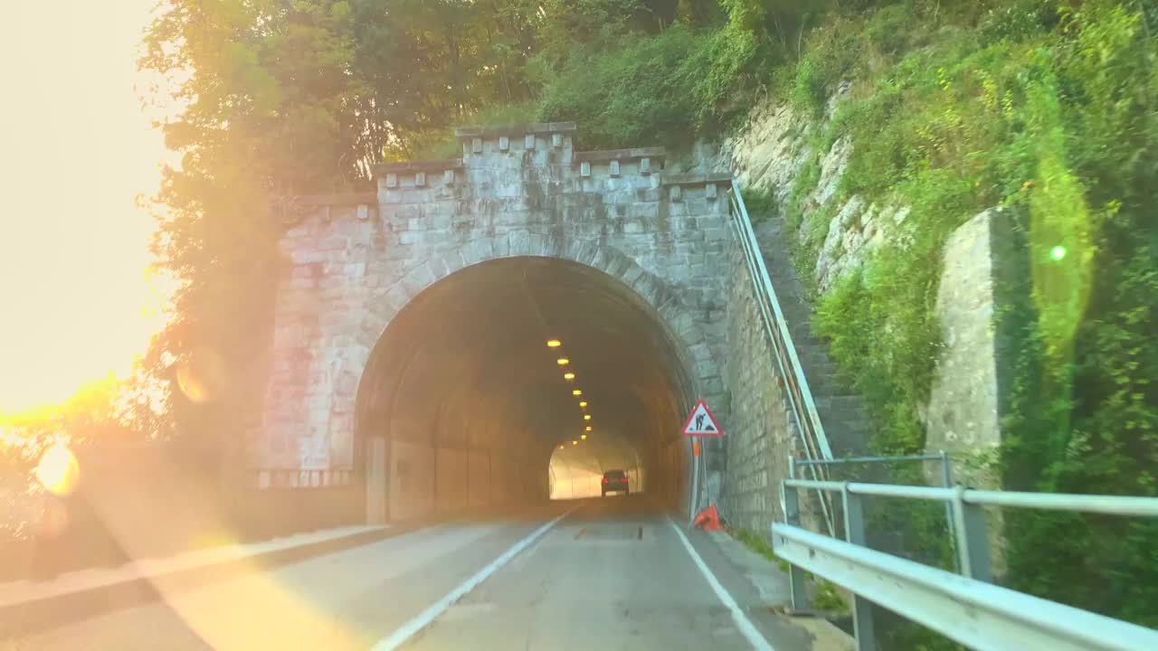 在一个阳光明媚的日子里，在山路上与高山湖泊卢加诺的汽车观点视频素材