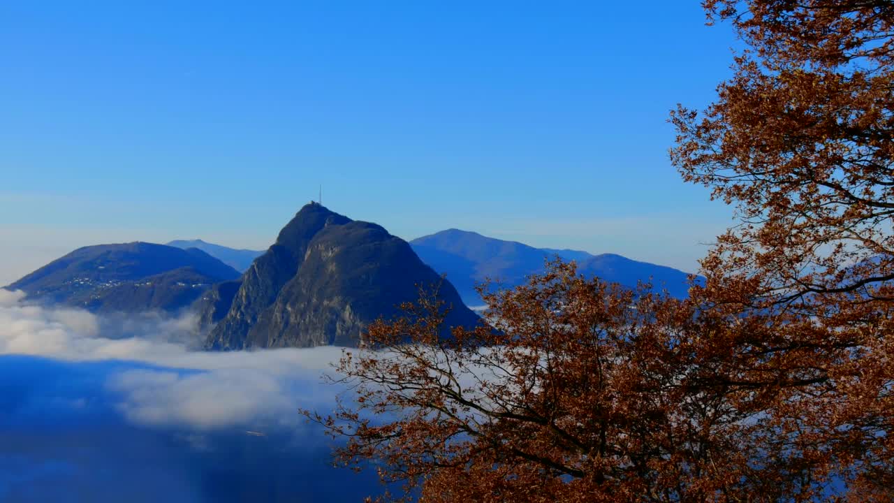 高山湖卢加诺的全景与云海和山在一个晴朗的秋日视频素材