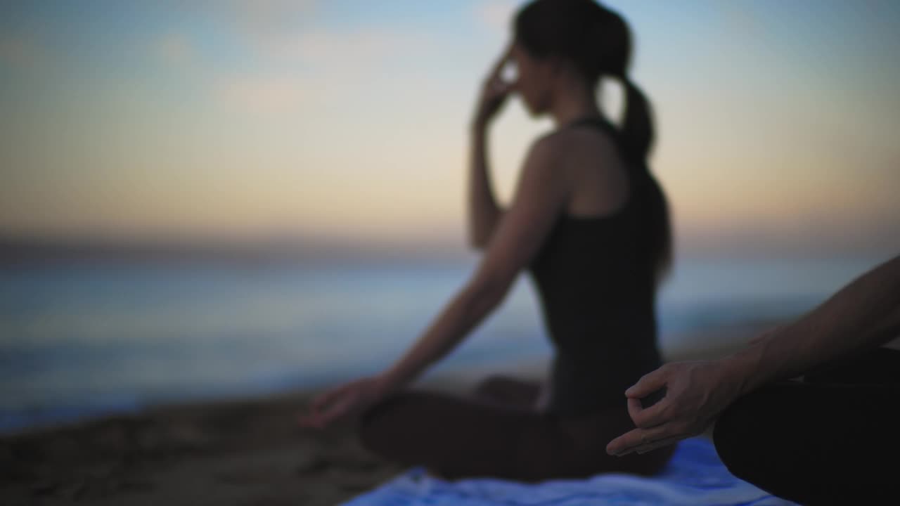 女人和男人在太平洋边做昆达里尼瑜伽视频素材