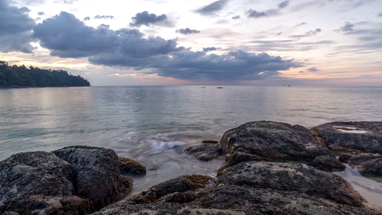 热带海滩日落与岩石海岸和海浪在考拉，攀牙泰国自然景观时间推移视频素材