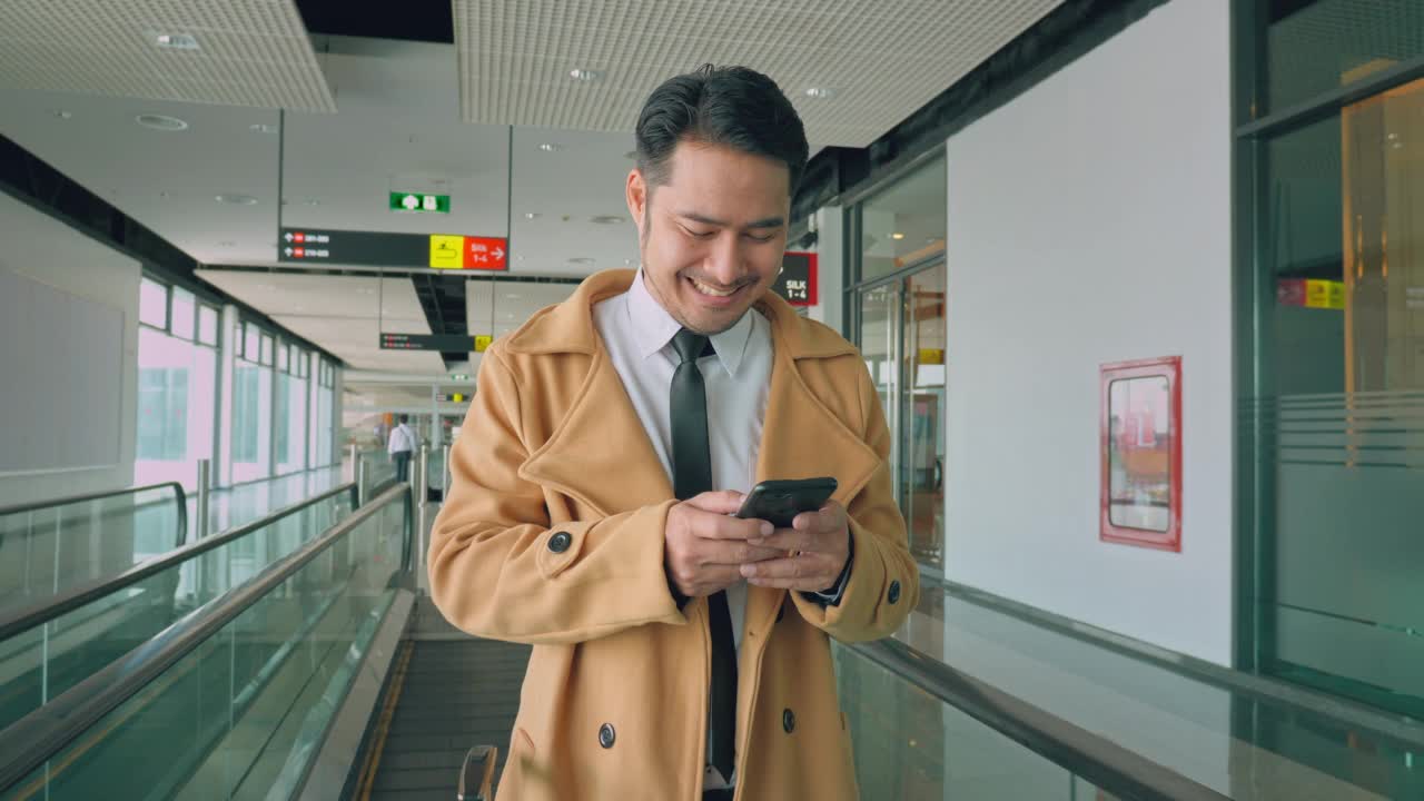 一位年轻的亚洲男子在机场与一位客户通电话视频素材