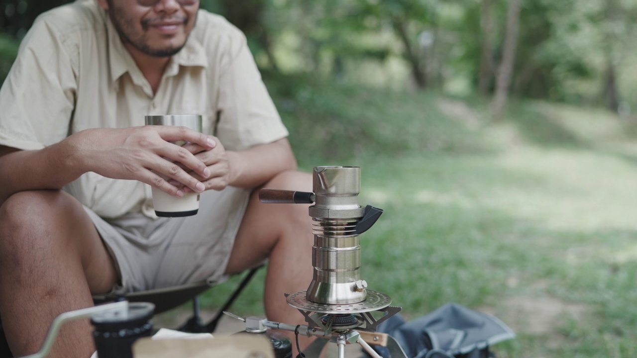 亚洲的年轻人喜欢在河边的树下做咖啡和野餐来放松自己视频素材