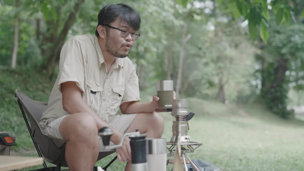 亚洲的年轻人喜欢在河边的树下做咖啡和野餐来放松自己视频素材