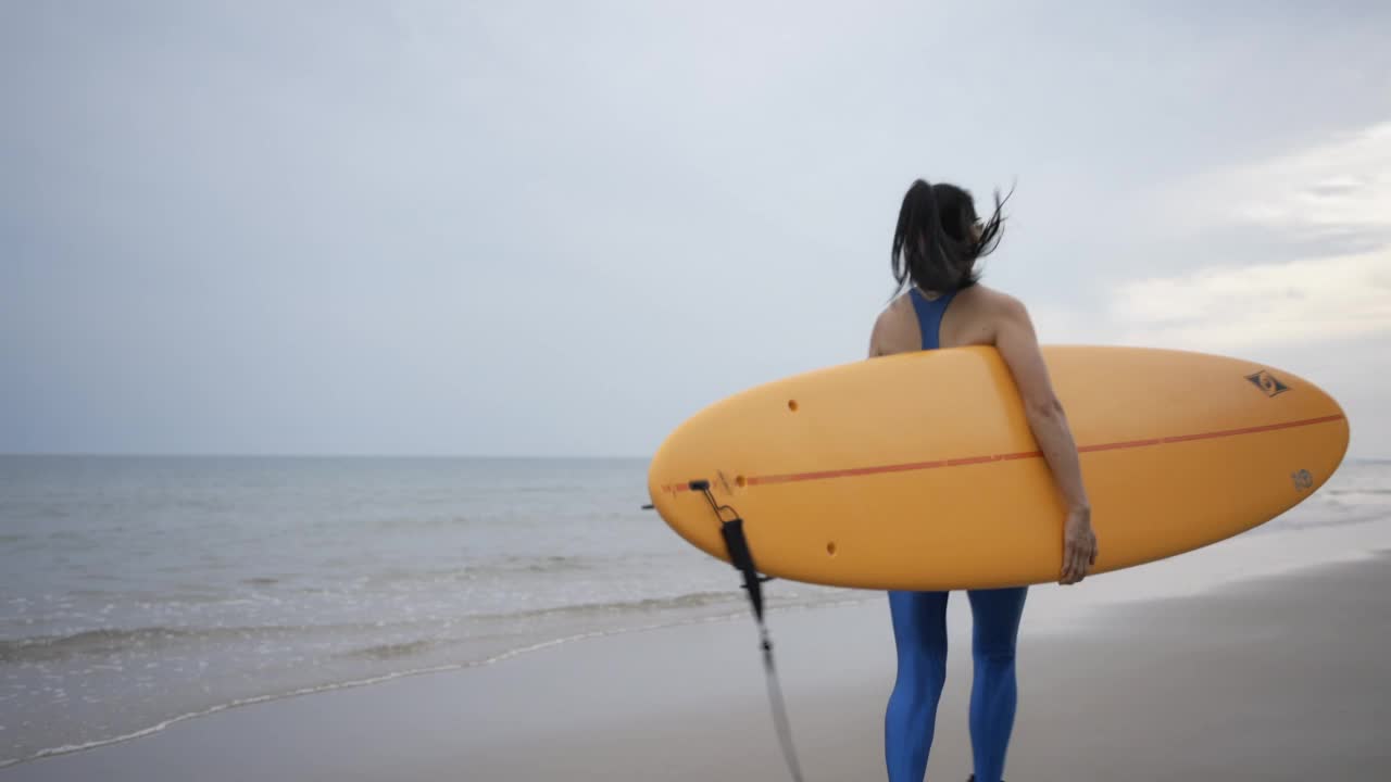 亚洲女子冲浪享受夏天冲浪板在海滩上，泰国。视频素材