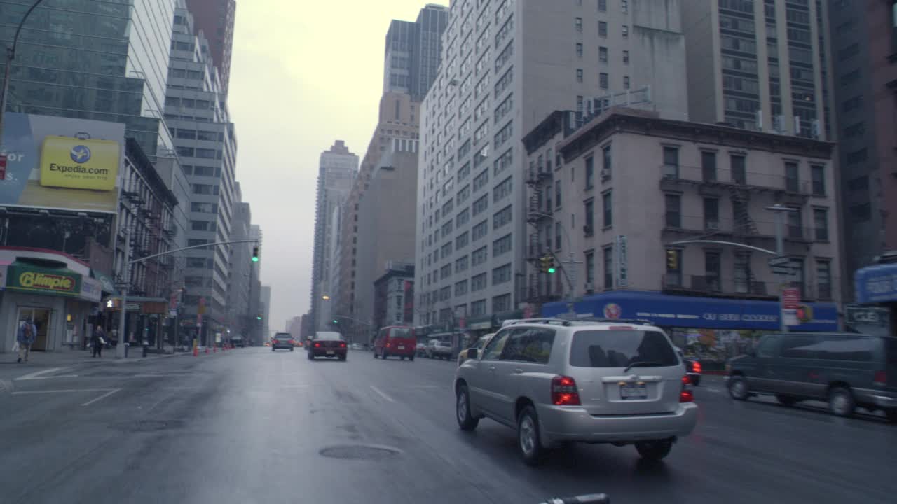 广角，纽约市东侧街道的全景图。纽约阴雨天的街道。轿车，出租车，越野车，轻车。通过杜安里德药店。视频素材