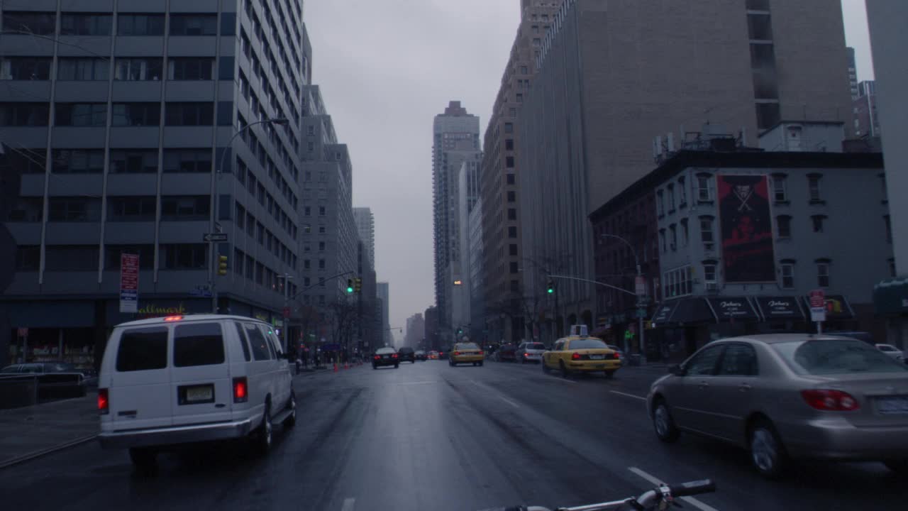 广角驾驶pov前进的纽约市，纽约市街道在一个雨天，阴天。汽车，公共汽车，越野车，轻轨交通，都铎式城市建筑。摩天大楼。视频素材