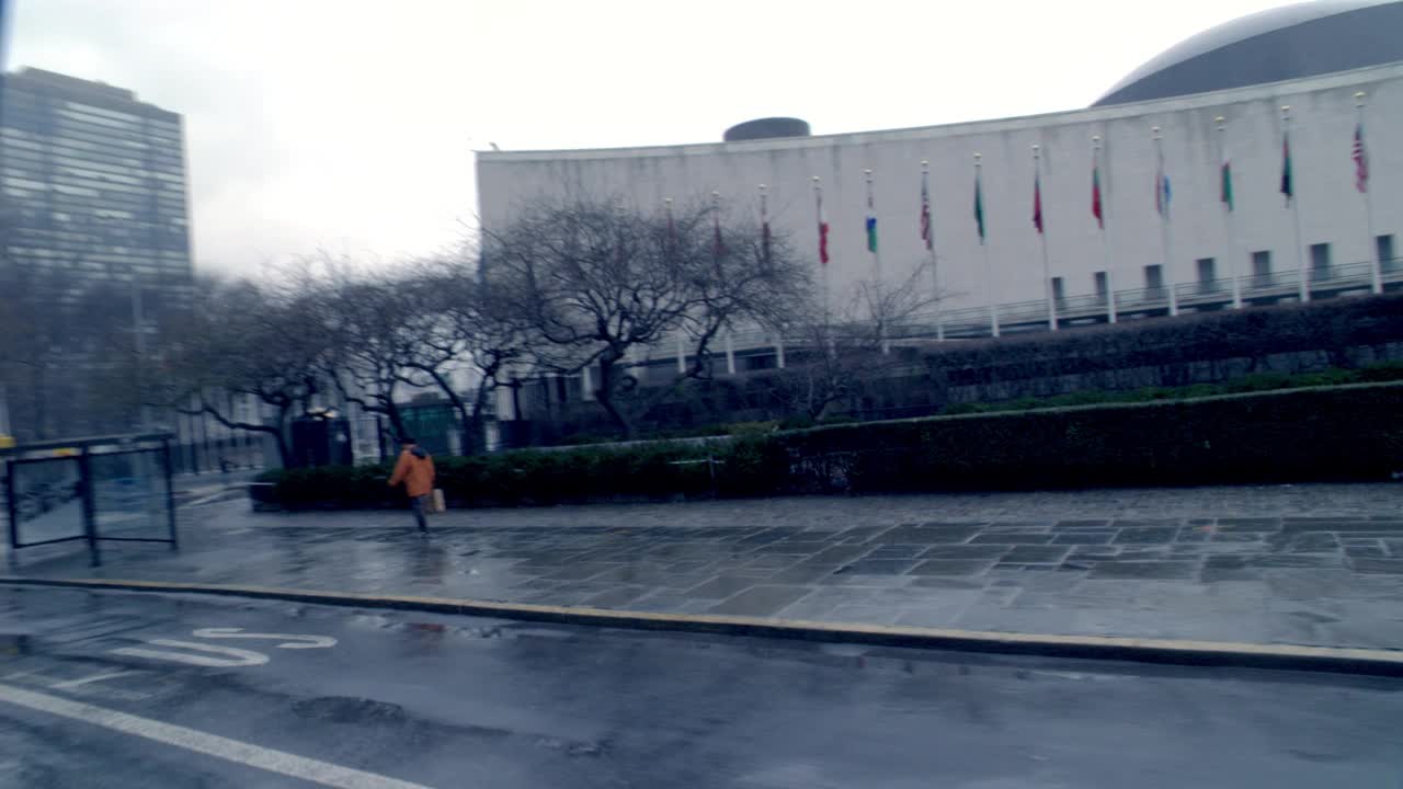 纽约联合国总部大楼前的街道，广角行驶。纽约阴雨天的街道。小汽车，公共汽车，越野车，轻车。视频素材