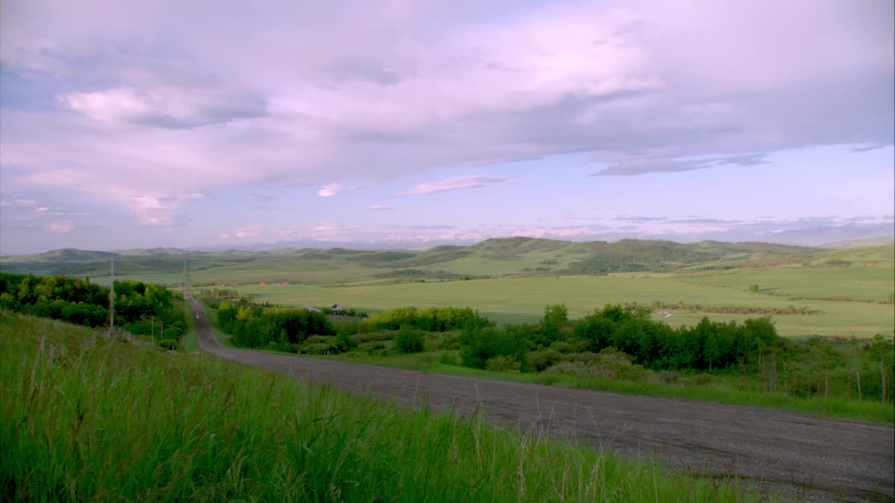 面包车在乡村道路上行驶的广角。草地或草地农村或农村地区视频素材