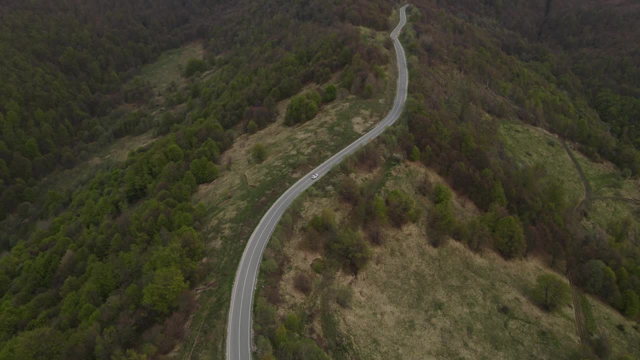 在道路上的俯瞰无人机跟随汽车，而驾驶旅游和旅游运输的概念，在秋天或冬天的一天，穿过田野和树木在塞尔维亚Knjazevac附近的老山stara planina视频素材