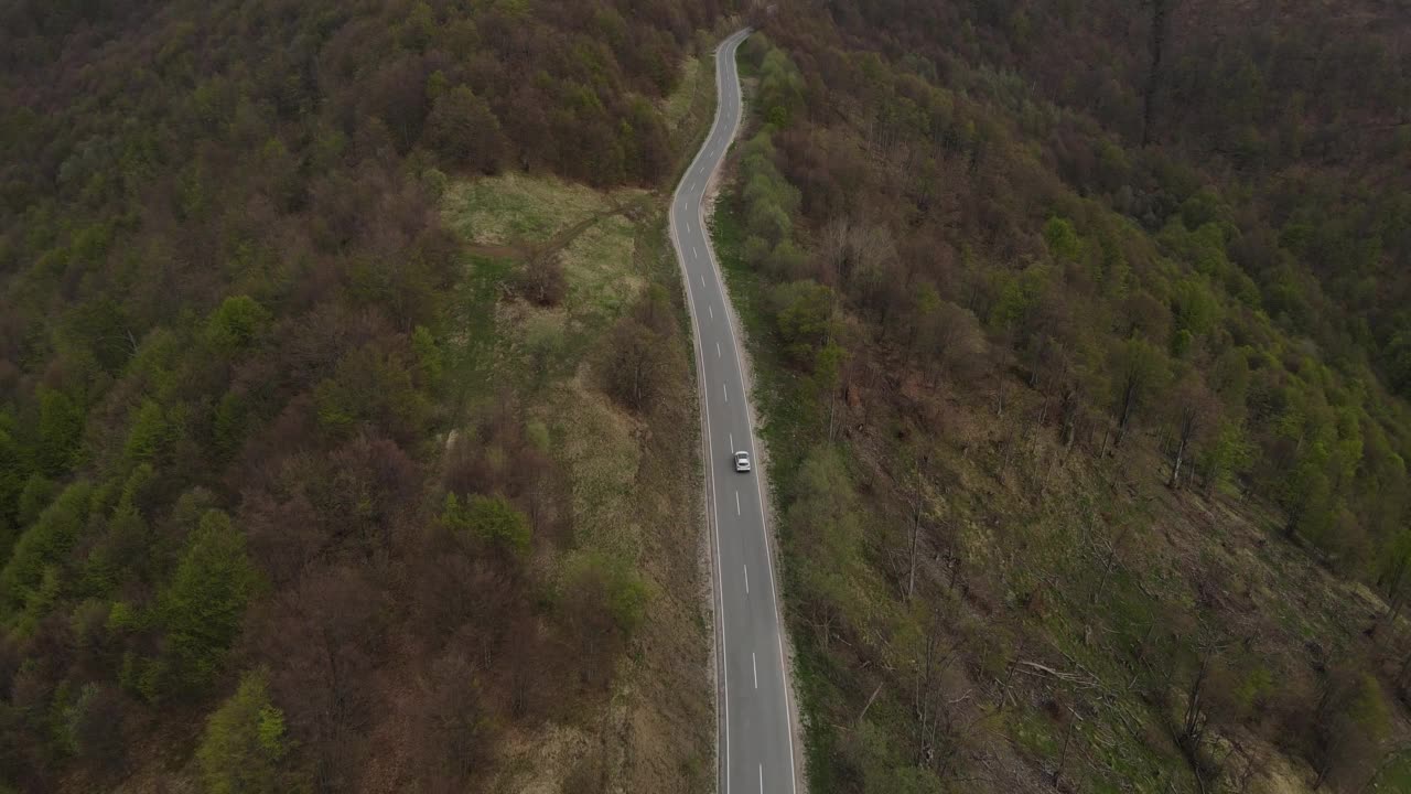 在道路上的俯瞰无人机跟随汽车，而驾驶旅游和旅游运输的概念，在秋天或冬天的一天，穿过田野和树木在塞尔维亚Knjazevac附近的老山stara planina视频素材