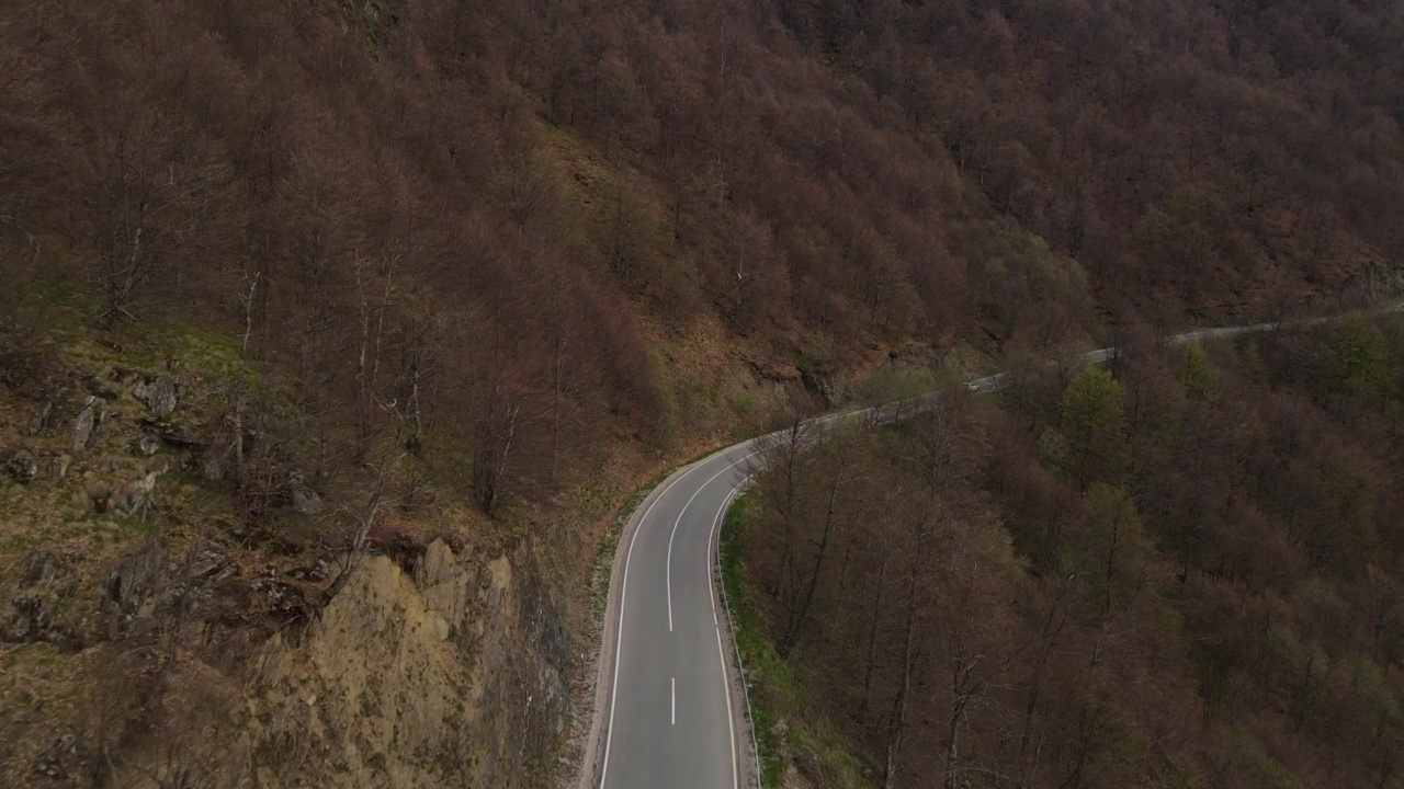 在道路上的俯瞰无人机跟随汽车，而驾驶旅游和旅游运输的概念，在秋天或冬天的一天，穿过田野和树木在塞尔维亚Knjazevac附近的老山stara planina视频素材