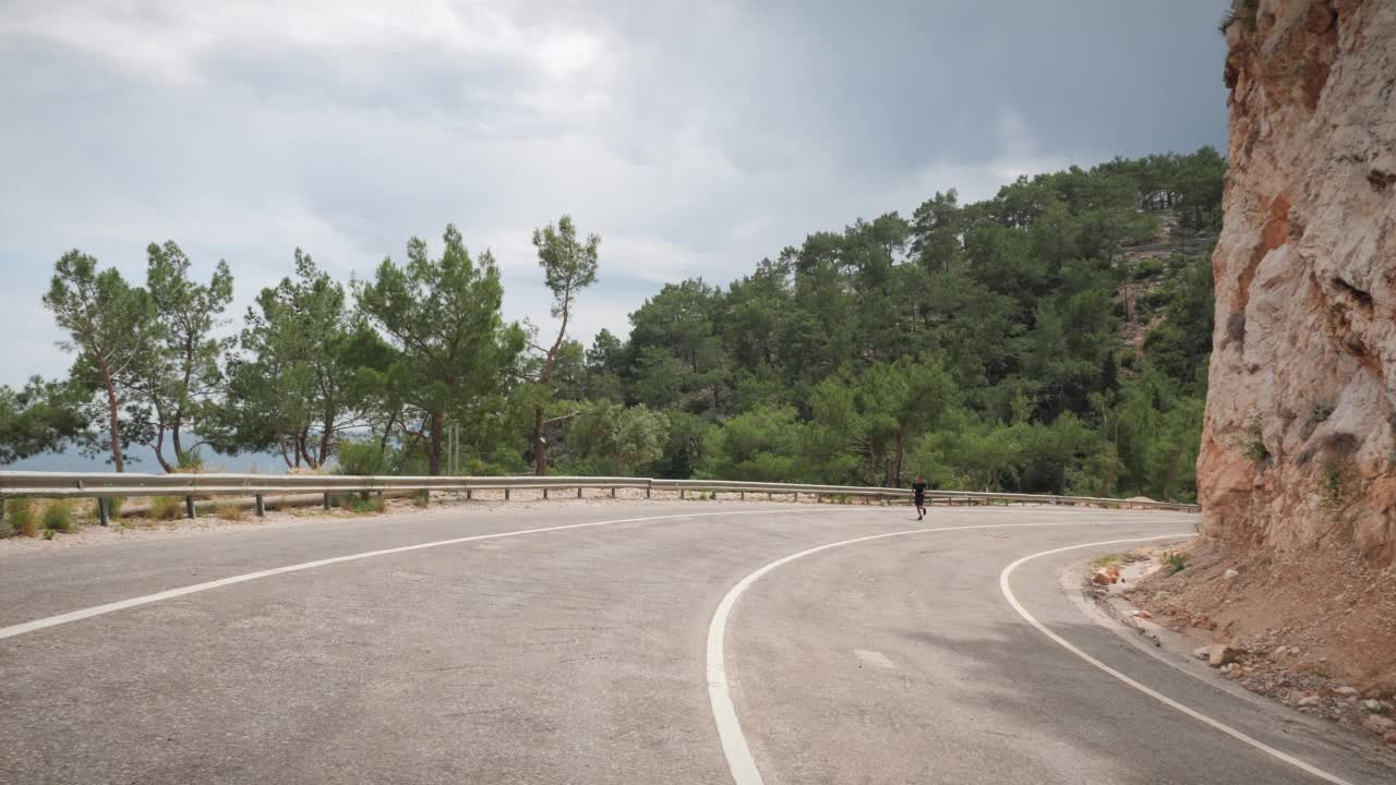 晨跑。年轻的肌肉男早上在山路上练习晨跑。铁人三项运动员在户外跑步，做耐力锻炼活动。健身锻炼。运动动机视频素材