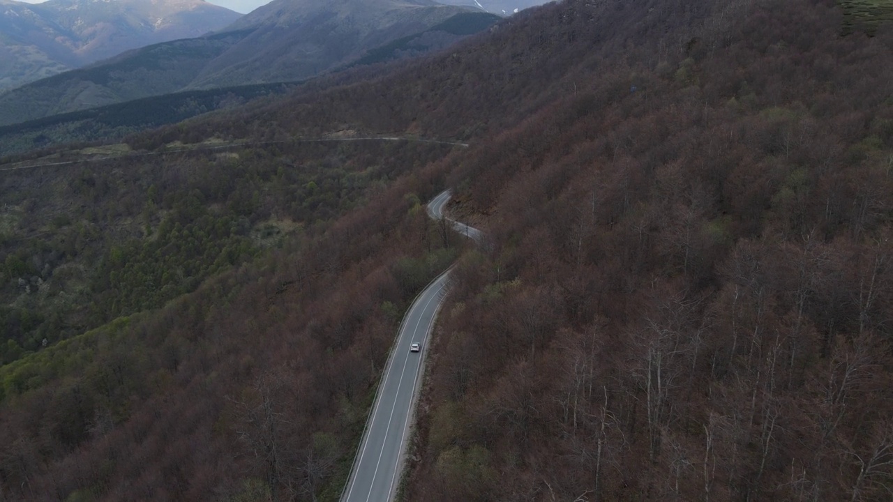 在道路上的俯瞰无人机跟随汽车，而驾驶旅游和旅游运输的概念，在秋天或冬天的一天，穿过田野和树木在塞尔维亚Knjazevac附近的老山stara planina视频素材