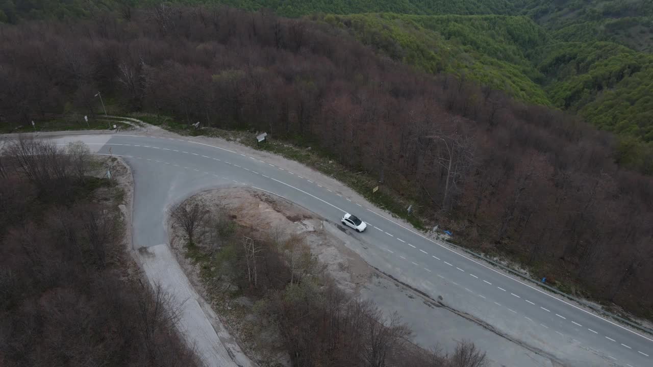 在道路上的俯瞰无人机跟随汽车，而驾驶旅游和旅游运输的概念，在秋天或冬天的一天，穿过田野和树木在塞尔维亚Knjazevac附近的老山stara planina视频素材