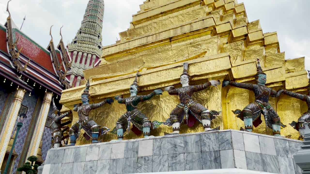 背景中的泰国武士雕像和大皇宫寺庙建筑的4K平移拍摄。宗教和观赏这些美丽的雕像令人敬畏。和平和平静剪辑没有人或人群视频素材