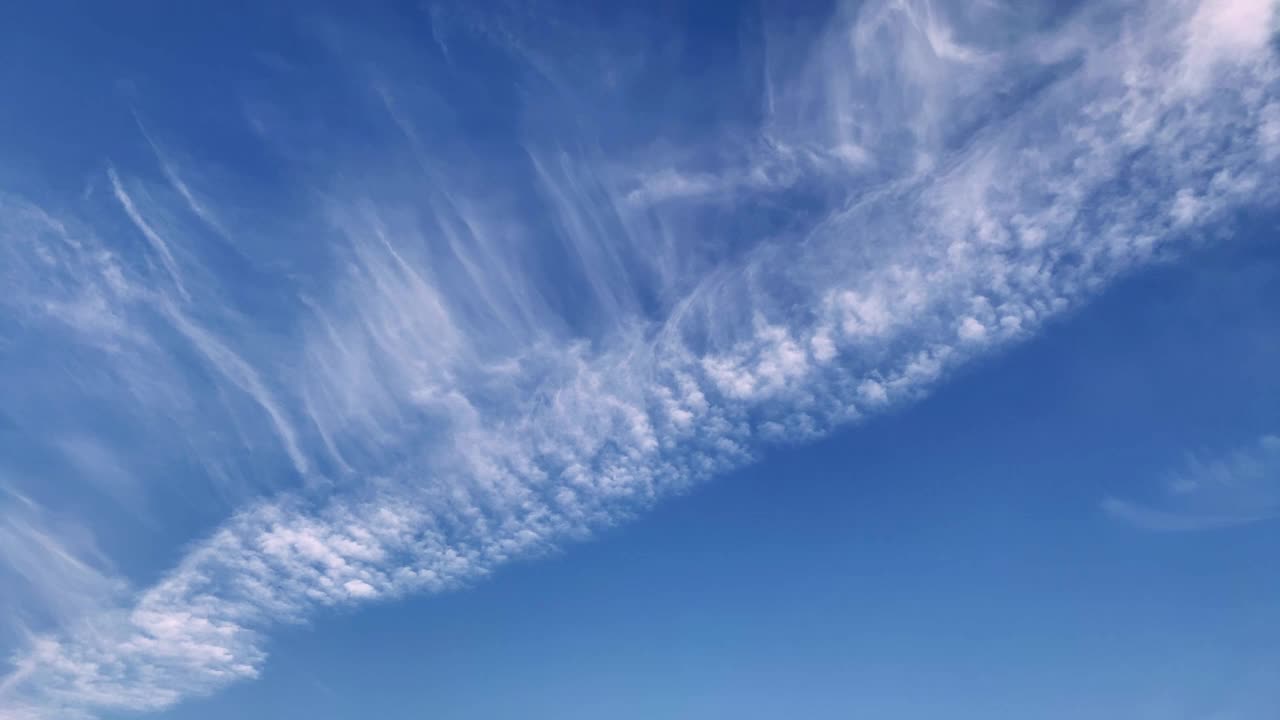 蓝色天空中流动的白色卷云和喷射轨迹的延时镜头。Cloudscape,日本。视频素材