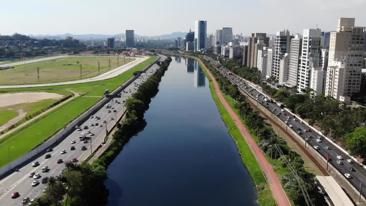 无人机鸟瞰图的一个大城市有一条河，高速公路和一个绿地视频素材