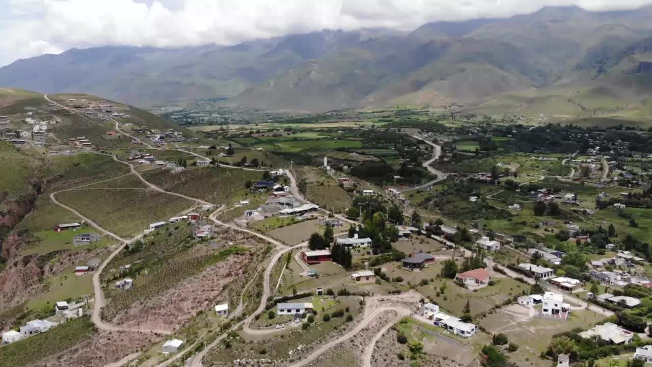 鸟瞰图的一个山村的房子在山上和山脊在远处视频素材