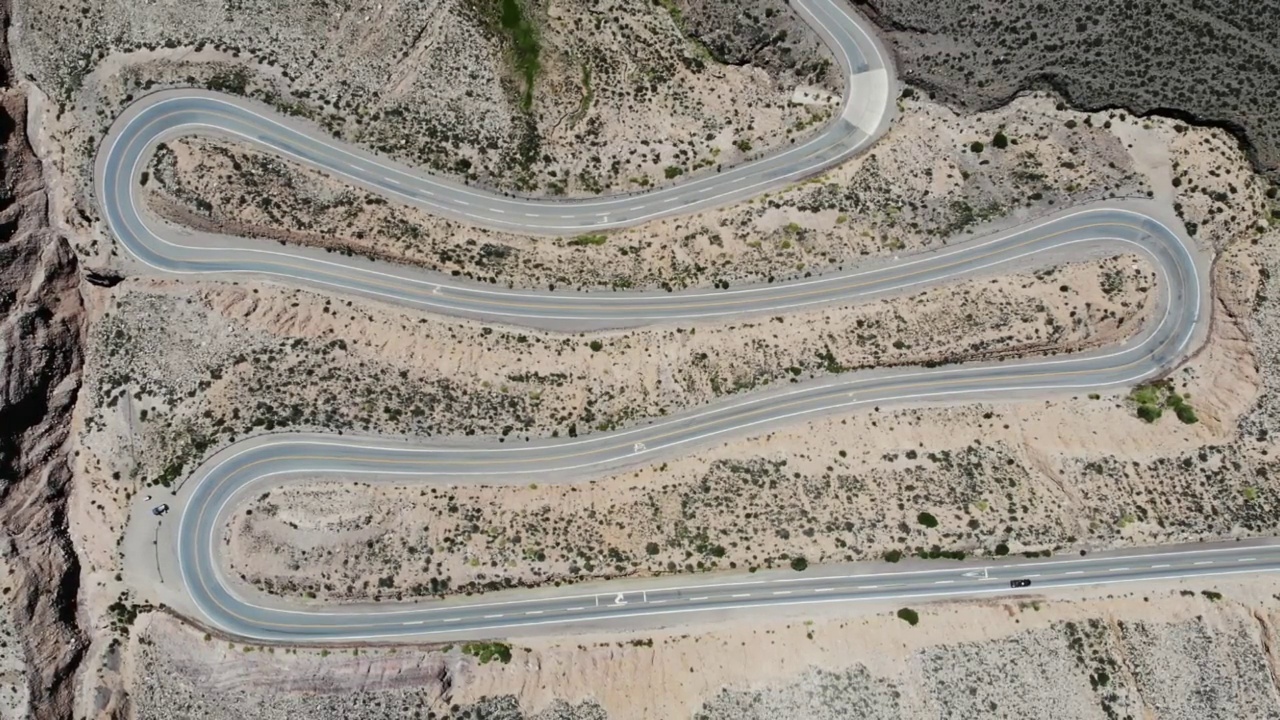 高空俯瞰有几个发夹弯和驾驶车辆的蜿蜒道路视频素材