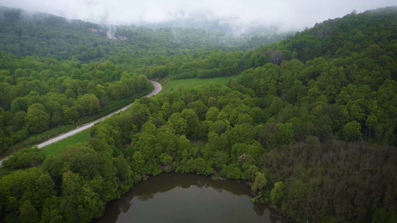 高加索地区卡巴尔迪诺-巴尔卡里亚的一个山间湖泊，湖水黑黝黝，沿岸树木茂密视频下载