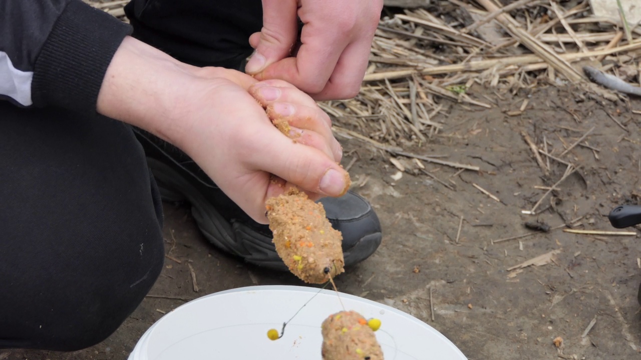 渔夫把鱼饵装入钓具钓鱼用。春天钓鱼。视频素材