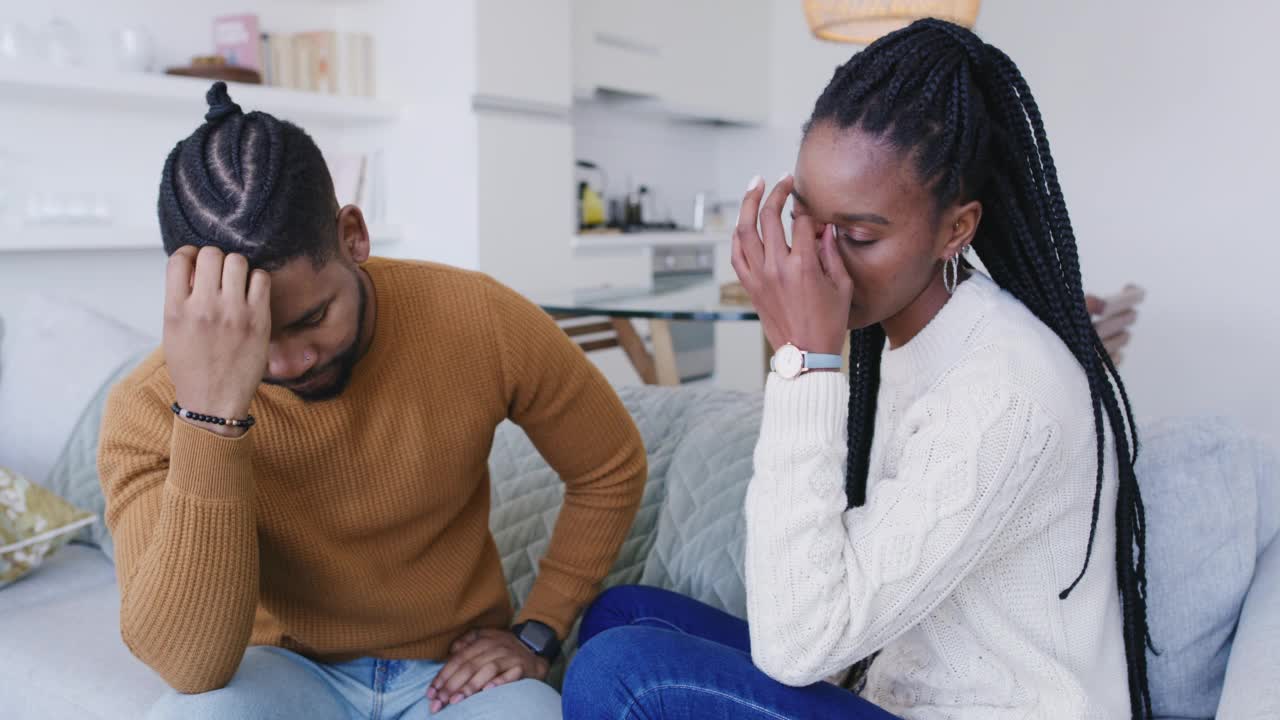 一对年轻夫妇在家里的沙发上吵架。有沟通问题的不快乐的男人和女人视频素材